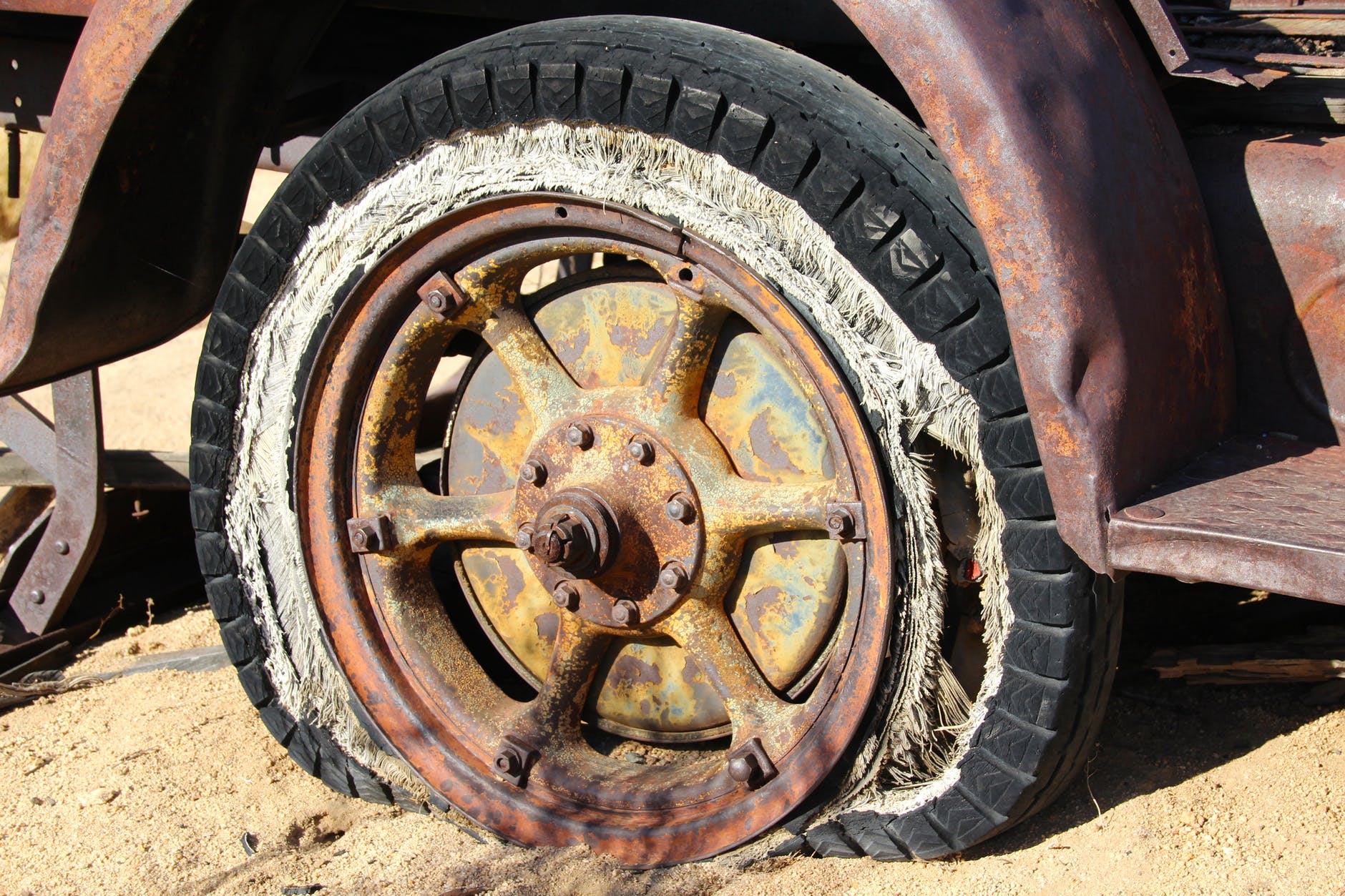 brown spoke car wheel in brown sand during daytime